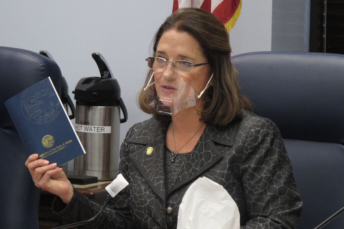FILE - In this Wednesday, Jan. 27, 2021 file photo, Alaska state Sen. Lora Reinbold, an Eagle River Republican, holds a copy of the Alaska Constitution during a committee hearing in Juneau, Alaska. Reinbold has been a vocal critic, along with other lawmakers, of Gov. Mike Dunleavy
