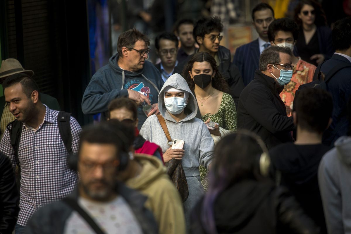 Pedestrians -- some masked, some not -- in midtown Manhattan on May 19, 2022. The United States remains better fortified against Covid deaths than it has ever been, scientists said.   (Dave Sanders/The New York Times)
