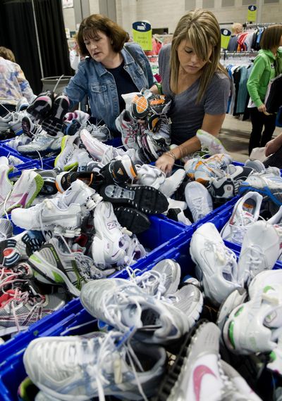 After picking up their Bloomsday race packets, Virginia Ramshaw, left, and her daughter Rachel rummage through bins of running shoes at the trade show Friday in the Group Health Exhibit Hall.  (Colin Mulvany / The Spokesman-Review)