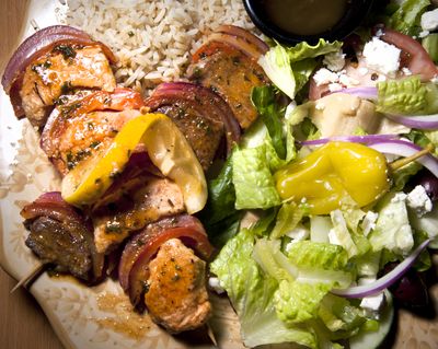 Souvlaki with Greek salad from Opa Pizza, Greek and Italian Cuisine features chicken and lamb marinated in white wine and olive oil with garlic served on a bed of rice. (Colin Mulvany)