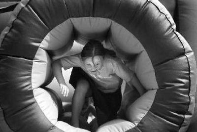 
Seven-year-old Emily Strahan of Spokane crawls through an obstacle course Tuesday at Neighbor Day in Riverfront Park..
 (Holly Pickett / The Spokesman-Review)