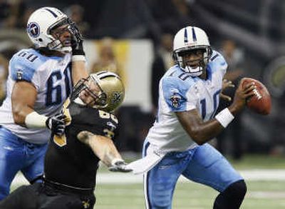 
As teammate Jacob Bell, left, flattens Brian Young, Titans quarterback Vince Young scrambles out of trouble. Associated Press
 (Associated Press / The Spokesman-Review)