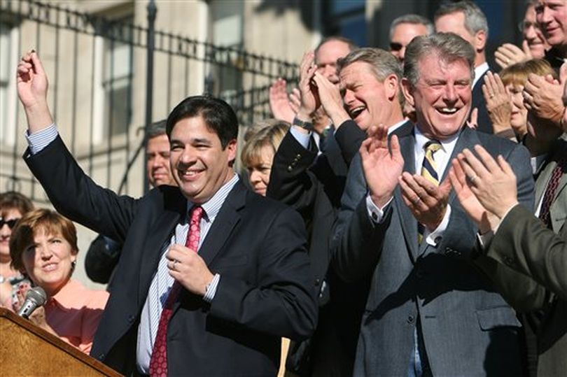 Idaho Republican Congressman-elect Raul Labrador, left, holds up his 