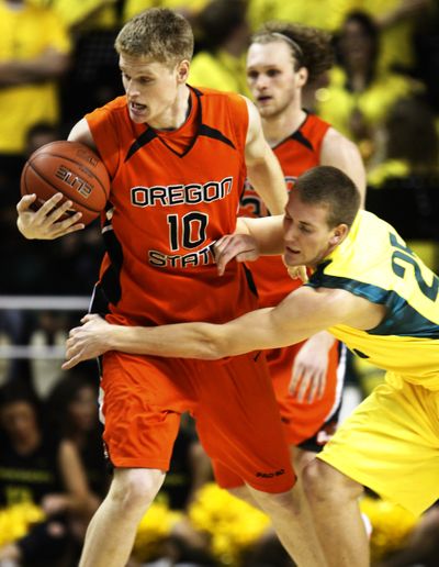 Oregon’s E.J. Singler reaches in as OSU’s Roeland Schaftenaar controls the ball during the first half. (Associated Press)