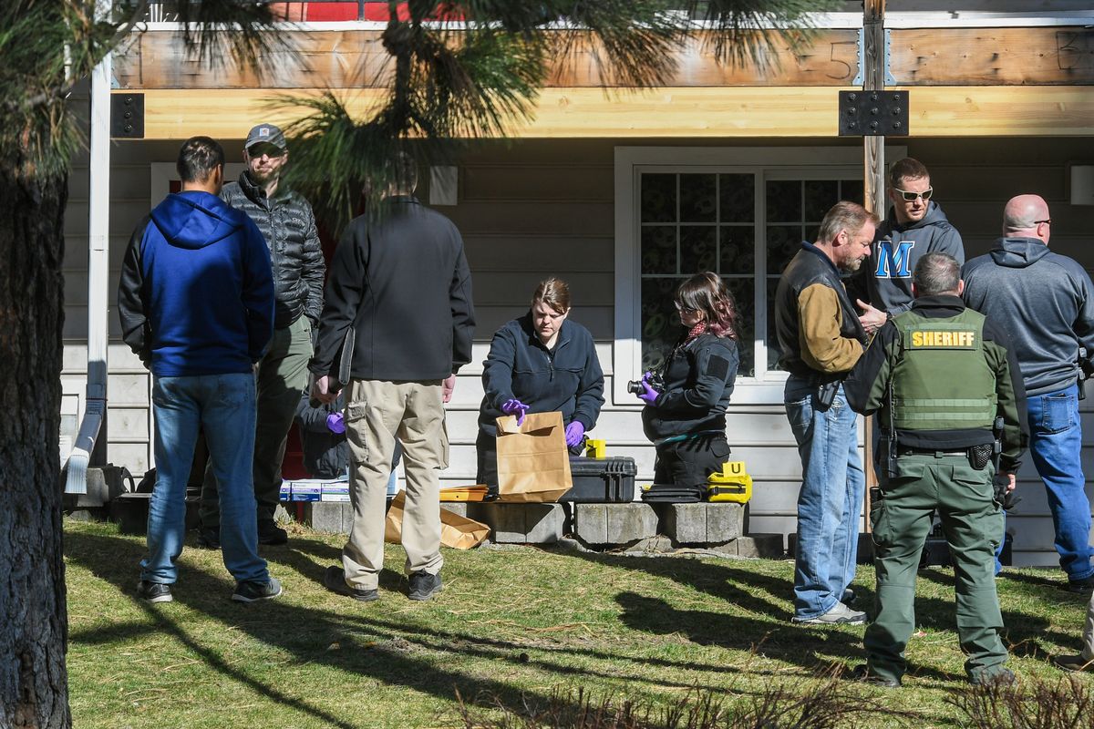 Members of the Spokane County Sheriff Forensic Unit, center, along with detectives, gather evidence while searching a unit at the Woodruff Heights Apartments, Tuesday, March 30, 2021, in Spokane Valley, Wash. A teenager was fatally shot late Monday night.  (Dan Pelle/THESPOKESMAN-REVIEW)