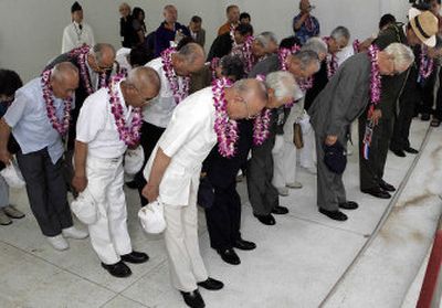 
World War II Japanese military pilots bow in respect  aboard the USS Arizona Memorial during a ceremony Thursday honoring the 65th anniversary of the Japanese attack on Pearl Harbor. 
 (Associated Press / The Spokesman-Review)