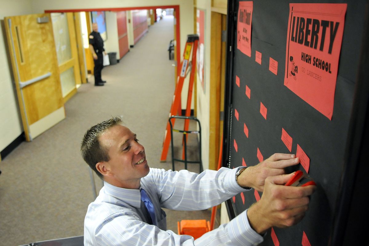 Aaron Fletcher, the new Liberty High School principal, trades banter with resource deputy Ron Nye, background, as Fletcher changes the names on the staff board Monday, the day before school starts.danp@spokesman.com (Dan Pelle / The Spokesman-Review)