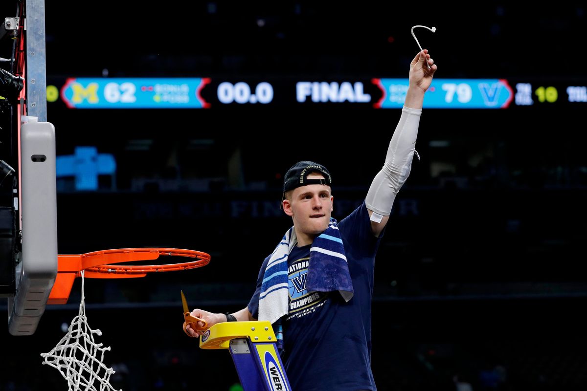In this April 2, 2018 photo, Villanova's Donte DiVincenzo cuts the net as he celebrates after the championship game of the Final Four NCAA college basketball tournament against Michigan in San Antonio. DiVincenzo is among the players seeking to test their NBA draft stock before deciding whether to stay in school. College players had until Sunday, April 22, 2018 to declare early for the NBA draft. Players who havent hired an agent can withdraw by May 30 to preserve their college eligibility. (AP Photo/David J. Phillip) ORG XMIT: NYPS201 (David J. Phillip / AP)