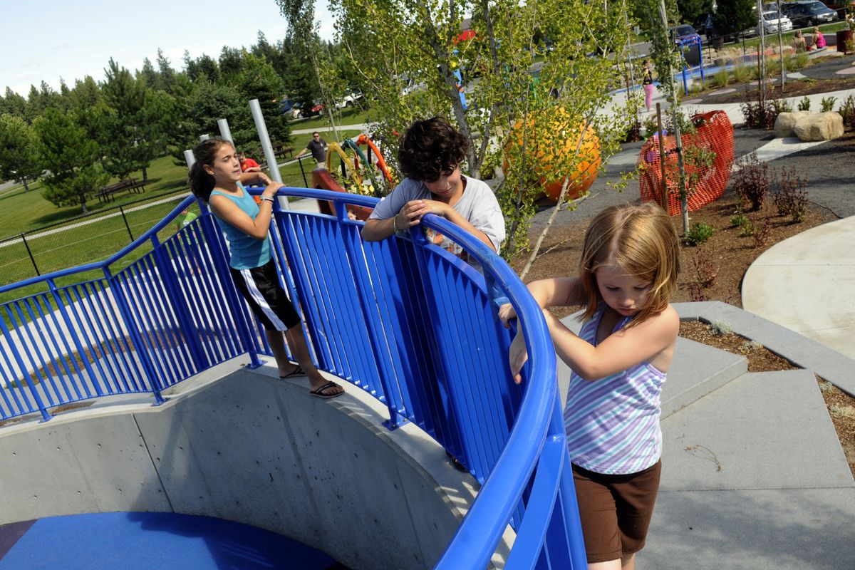 Discovery Playground users find an unintended use for the protective barrier surrounding the double slide and sensory garden Tuesday.