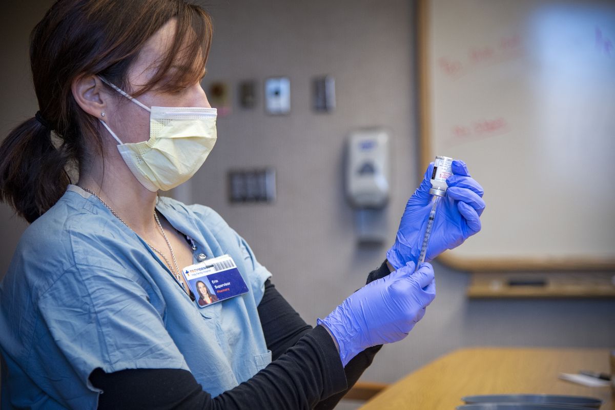 Pharmacist Erin White measures doses of the Moderna vaccine, Friday, Jan. 22, 2021, at a pop-up clinic at Holy Family Hospital in north Spokane. The vaccination clinic, one of the first for people over 65, will administer 1400 doses over three days. Next week, mass vaccinations will begin at the Spokane Arena.  (Jesse Tinsley/The Spokesman-Review)