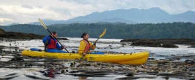 
Chris Eccles, left, and Celia Nieto, paddle a kayak through a kelp forest in Freshwater Bay during an August trip, with the Olympic Mountains in the distance west of Port Angeles.
 (Associated Press / The Spokesman-Review)