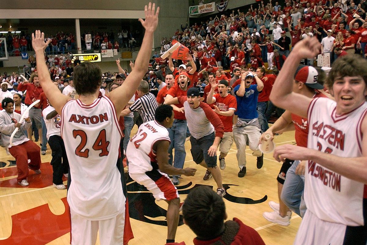 Fans swarm the court to celebrate with players Marc Axton, left, Alvin Snow and Josh Bernard after Eastern Washington’s 2004 victory over Northern Arizona in Cheney that earned the school its first NCAA Tournament berth. (DAN PELLE/The Spokesman-Review)