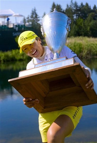 M.J. Hur almost tips over from the weight of the trophy after winning the Safeway Classic golf tournament Sunday, Aug. 30, 2009, at the Pumpkin Ridge Golf Club in North Plains, Ore. Hur won the tournament in a playoff against Suzann Pettersen. (Randy L. Rasmussen / AP Photo/The Oregonian)