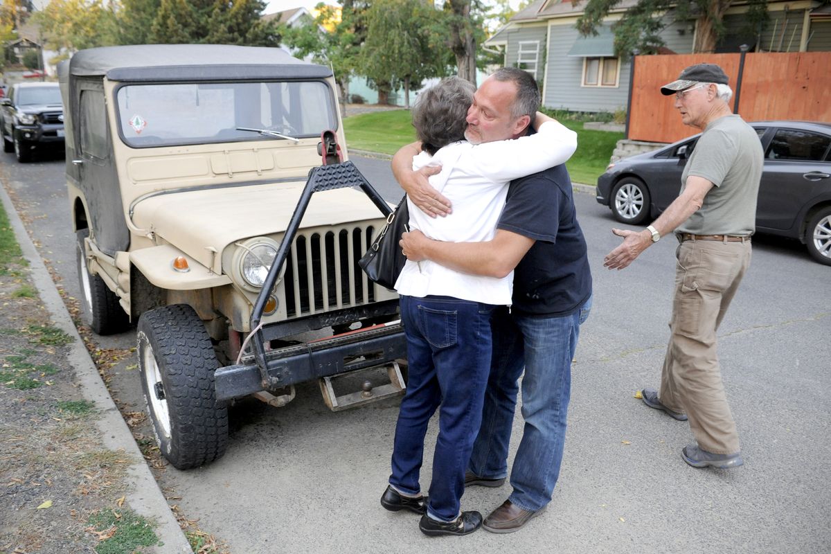 Steve Heidal hugs his mother, Patty, while his father, Gary, looks over their 1951 Jeep that was found Wednesday in north Spokane. The Jeep had been stolen, and the family was distraught because the vehicle had been in their family for 39 years. (Jesse Tinsley)