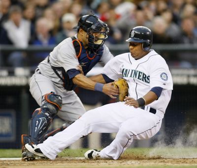 M’s Jose Lopez is out trying to score on a fly ball.  (Associated Press / The Spokesman-Review)