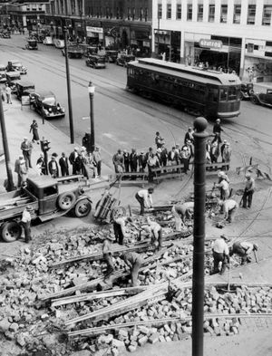 Transition: Workers from Spokane United Railways remove streetcar tracks at the intersection of Riverside Avenue and Howard Street on Sept. 14, 1935.