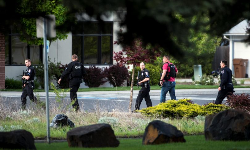 Law enforcement search for a suspect at Division Street and Cozza Ave. in Spokane on Thursday. (Colin Mulvany / The Spokesman-Review)