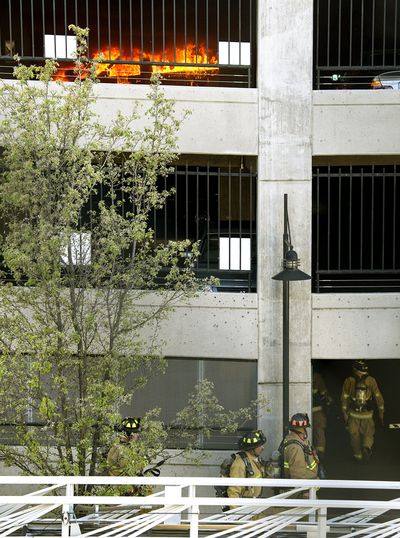 Spokane firefighters enter the Parking West garage at 1102 W. Sprague Ave. to put out a vehicle fire Monday evening. (Colin Mulvany)