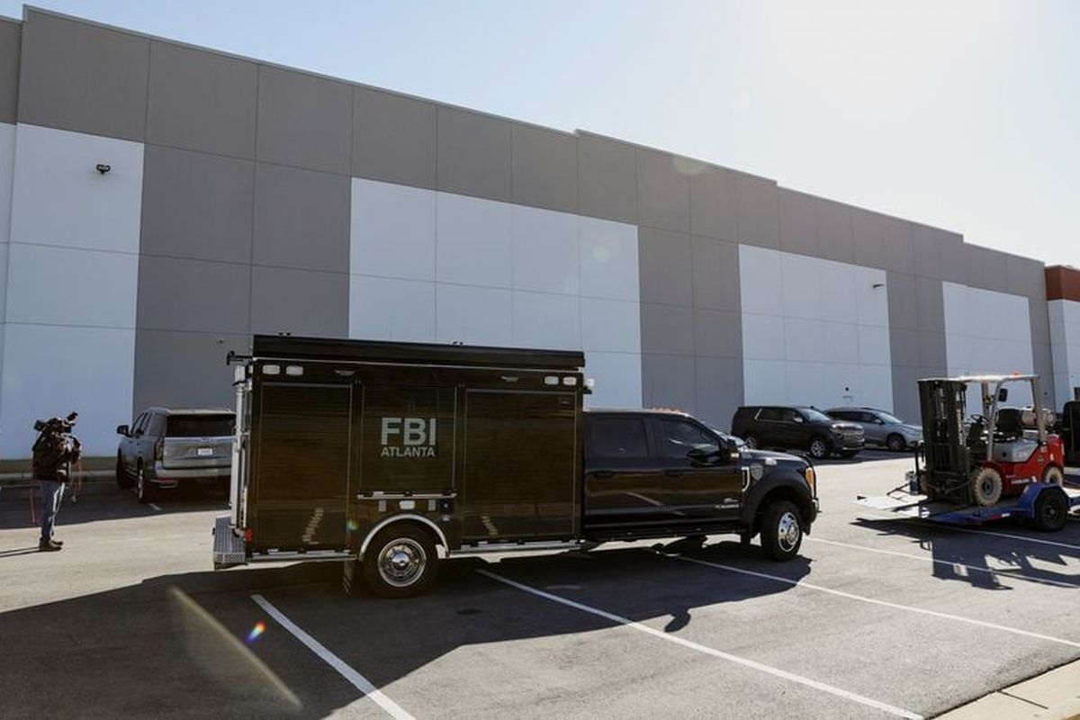 The Federal Bureau of Investigation is parked outside the Fulton County Election Hub and Operation Center Wednesday after the FBI executed a search warrant there in relation to the 2020 election, according to a law enforcement official familiar with the matter, in Union City, Ga.  (Alyssa Pointer/Reuters)