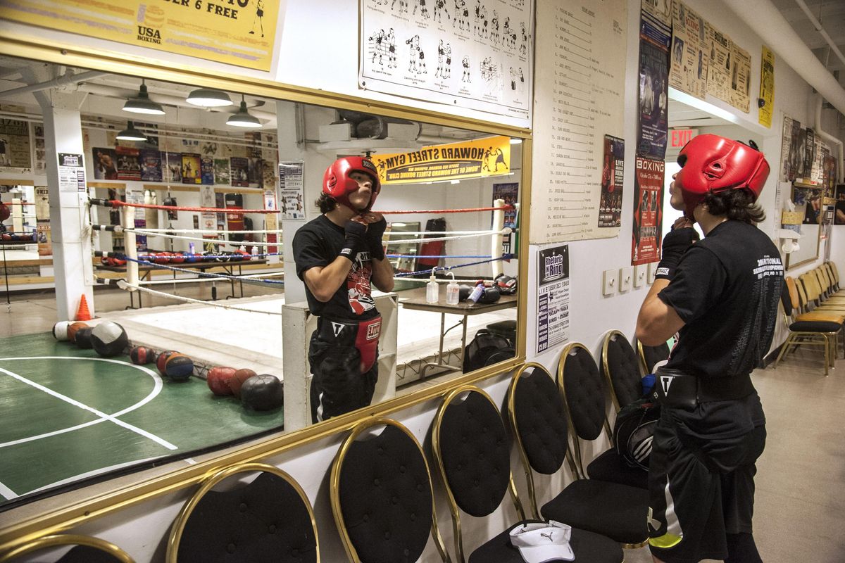 Israel Alvarez puts on his protective gear during training at the Howard Street Gym, June 22, 2016. (Dan Pelle / The Spokesman-Review)