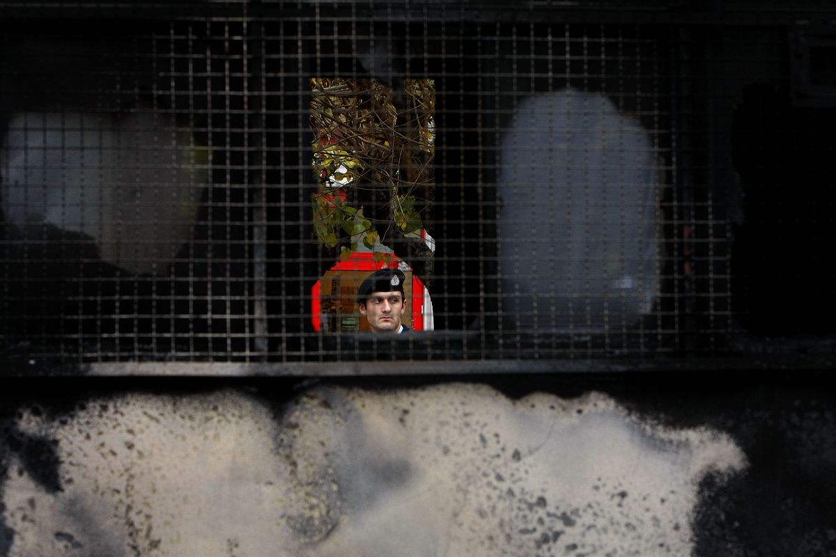 A police officer is seen through the cracked window of a police bus in Athens, Greece, Wednesday Dec. 17, 2008. Youths threw petrol bombs at a riot police bus on Wednesday, police said, adding that the driver managed to escape unharmed.  Although rioting has abated from recent levels of clashes between police and demonstrators, small-scale attacks still continue.  (Petros Karadjias / AP)