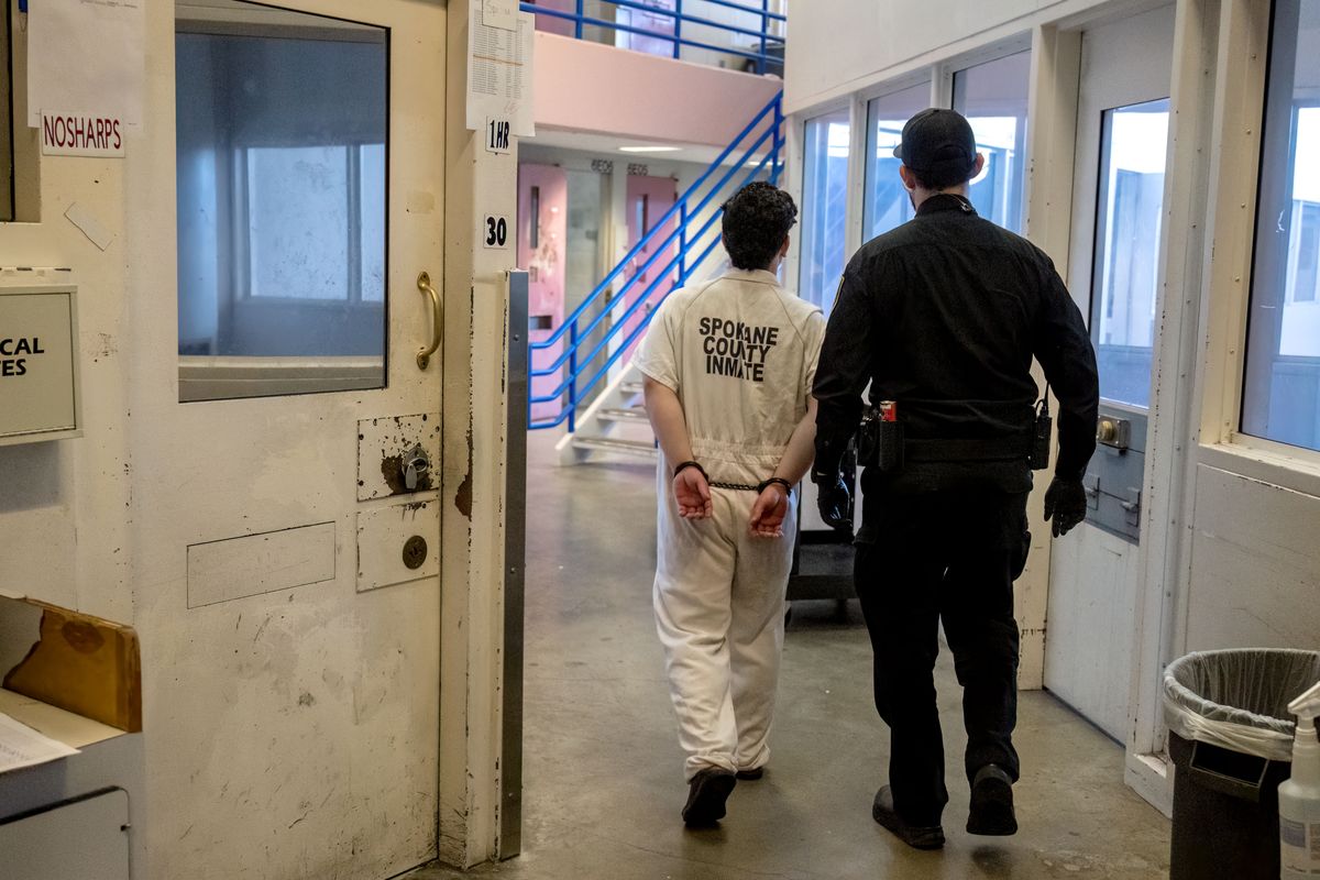 An Inmate in the 6E maximum security floor in the Spokane County Jail is escorted by a corrections officer in June 2024.  (COLIN MULVANY/THE SPOKESMAN-REVIEW)