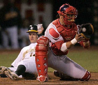 
Oakland's Mark Ellis slides into home before Red Sox catcher Javy Lopez applies the tag in Monday's game.
 (Associated Press / The Spokesman-Review)