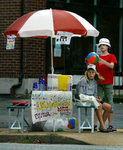 
Mim Murray, 10, standing, and Marisa Miller-Stockie, 12, of St. Louis, wait for customers at their lemonade stand on Wednesday in St. Louis. 
 (Associated Press / The Spokesman-Review)