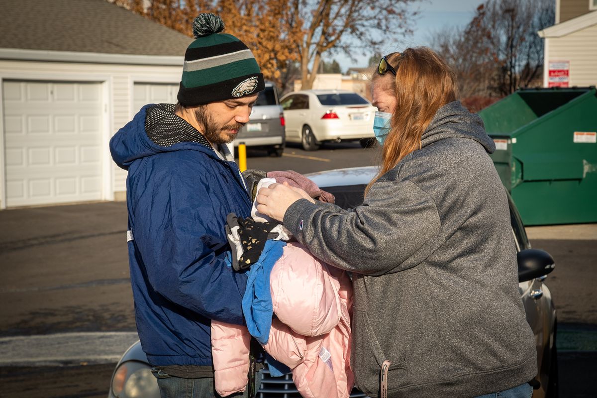Kevin Hulme is handed donated clothes for his children by Regal Ridge Apartments manager Maggie Olney on Tuesday after a fire destroyed his family’s apartment. Hulme said his two children jumped from the third-story window to escape the flames. One child was taken to the hospital with injuries that were not life threatening.  (Colin Mulvany/THE SPOKESMAN-REVIEW)