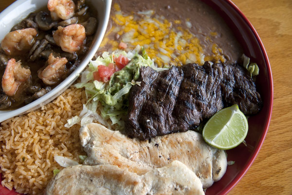 Adelita’s Platter on La Plaza de Mexico’s menu includes grilled skirt steak, grilled chicken and camarones al mojo de ajo. Rice, beans and guacamole, along with warm tortillas, finish the meal. (Dan Pelle)