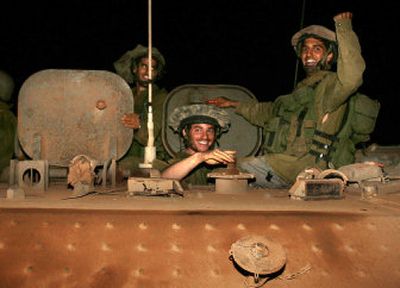 
Israeli soldiers ride on top of an armored vehicle after crossing the border from southern Lebanon into northern Israel early today. 
 (Associated Press / The Spokesman-Review)