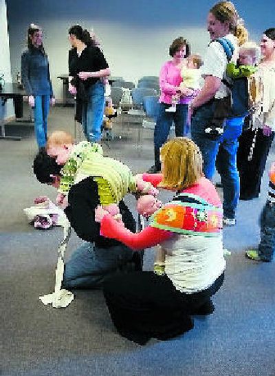 
Sarita Morgan, right,  helps Miranda Gordon, with her wrap during a meeting at the Spokane Library  on the South Hill. 
 (The Spokesman-Review)