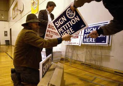 
Dave Gilbert, left, Rick Lloyd and Ken Crigger, right, assemble signs last week supporting the grass-roots effort to dissolve the city of Spokane Valley.
 (Liz Kishimoto / The Spokesman-Review)