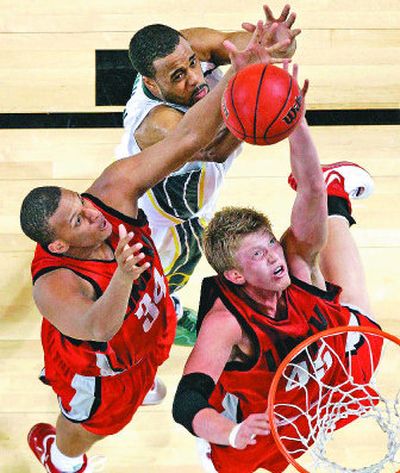 
Oregon's Malik Hairston, top, battles UNLV's Matt Shaw, left, and Joe Darger for a first-half rebound Friday in St. Louis. 
 (The Spokesman-Review)