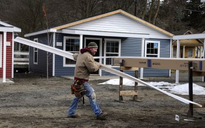 At Latah Creek Cottages, Ethan Bratrud, a construction worker with Wells & Co., installs vinyl siding on one of 12 former motor court cottages being upgraded to condos. Prices start at $119,000. (Colin Mulvany / The Spokesman-Review)