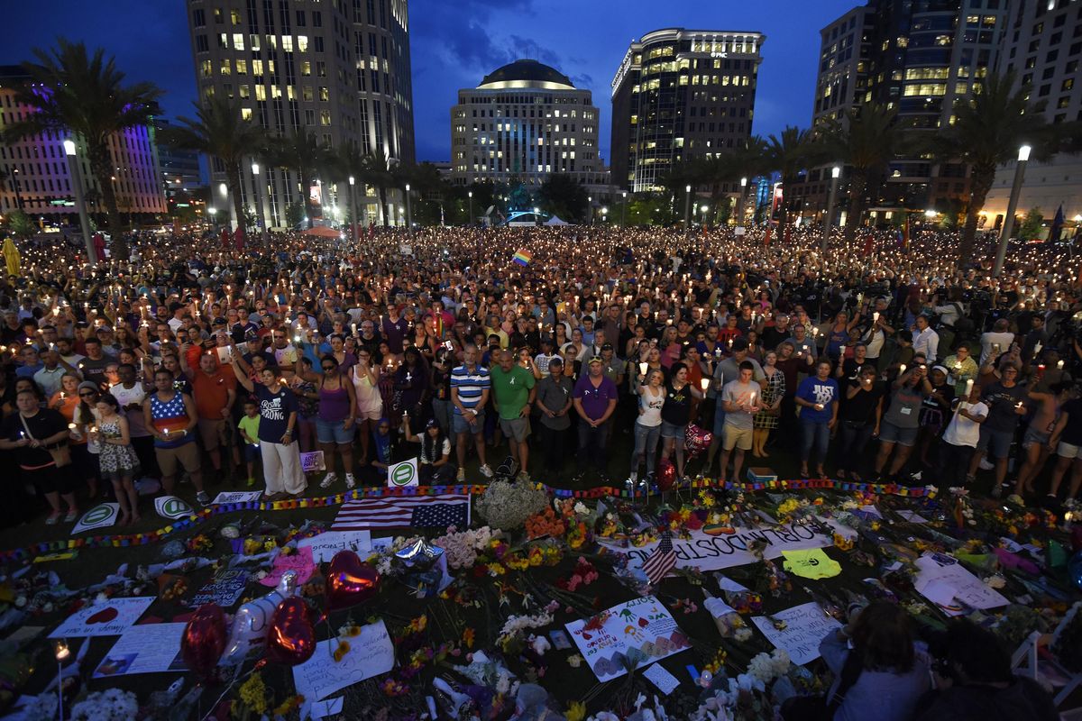 Thousands gather outside the Dr. Phillips Performing Arts Center for a vigil Monday, June 13, 2016 in Orlando, Fla. A large crowd gathered to remember the Pulse nightclub shooting victims early Sunday. (Chris Urso / Tampa Bay Times via Associated Press)