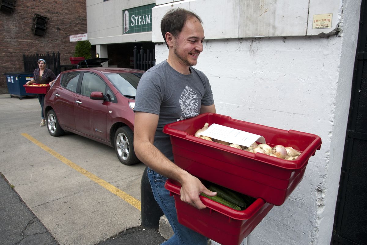 Joel Williamson and Beth Robinette, founders of LINC Foods, deliver an order of locally grown produce to the Stacks at Steam Plant on Aug. 15. Their goal is to give small farmers more ways to sell products to local customers. (Dan Pelle)