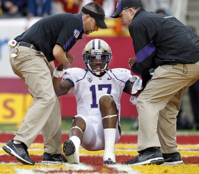 Washington quarterback Keith Price is helped up in the end zone after a safety during the first half of an NCAA college football game against Southern California in Los Angeles, on Saturday, Nov. 12, 2011. (Christine Cotter / Fr170214 Ap)