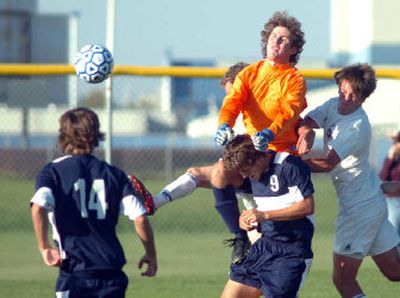 
Lake City goalie Scott Klein (in orange) leaps into a crowd to punch away a ball for a save. 
 (Jesse Tinsley / The Spokesman-Review)