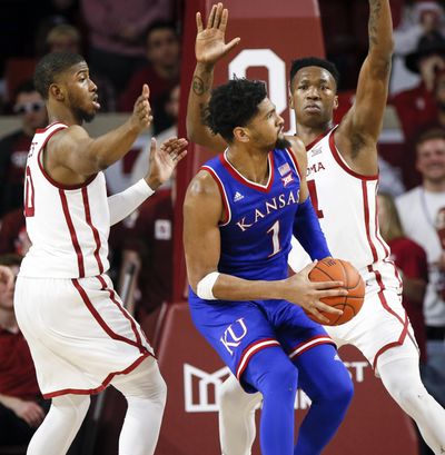 Kansas forward Dedric Lawson, center, tries to get to the basket between Oklahoma guard Christian James, left, and forward Kristian Doolittle, right, in the second half of an NCAA college basketball game in Norman, Okla., Tuesday, March 5, 2019. Oklahoma won 81-68. (Nate Billings / Associated Press)