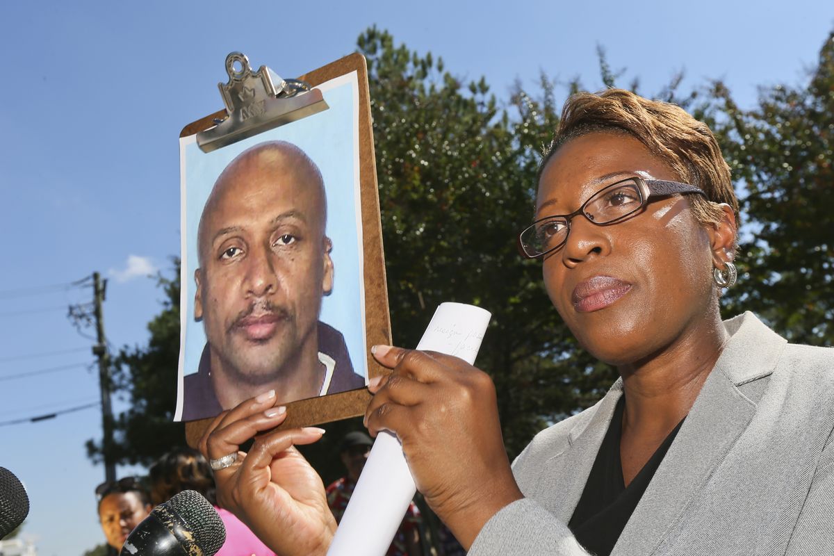 Fulton County Police public information officer Kay Lester holds up the picture of Floyd Palmer, the suspect being sought in a fatal shooting at World Changers Church International in College Park, Ga. Wednesday, Oct. 24, 2012. A church volunteer leading prayer was shot and killed inside the chapel of the megachurch. (John Spink / Atlanta Journal-constitution)