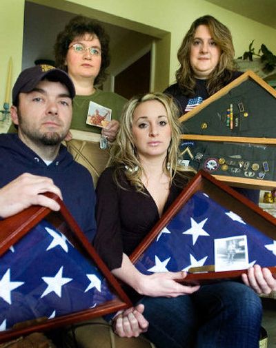 
The children of Daniel Kuttner and George Mason – clockwise from bottom left are Christian Michael Kuttner, Stacie Ketchum, Michelle Carlson and Tammi Mason –  hold their fathers' uniforms, service medals and flags from their burial services.  
 (Photos by Christopher Anderson / The Spokesman-Review)
