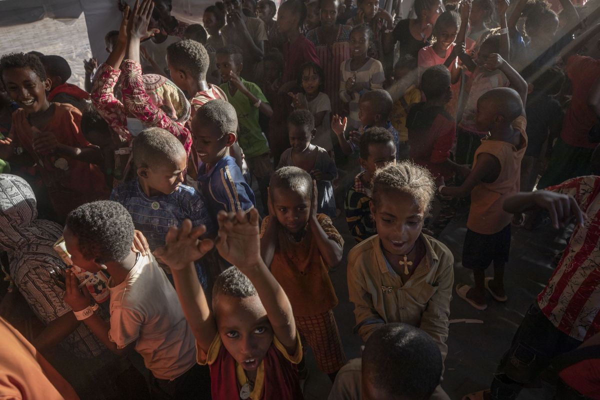 Tigray refugee children sing and dance inside a tent run by UNICEF for children