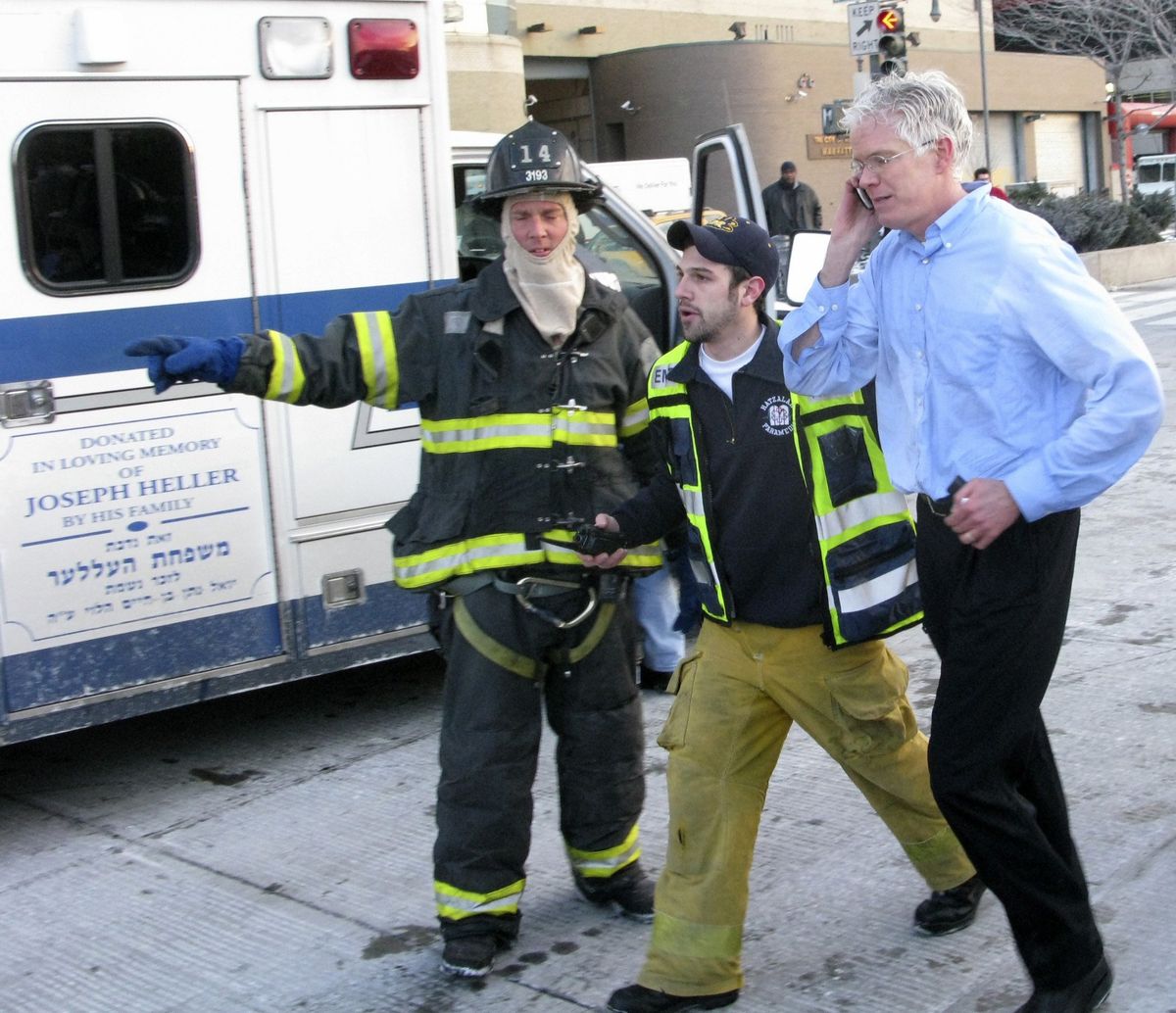 Authorities move a passenger to a waiting ambulance Thursday. (Associated Press / The Spokesman-Review)