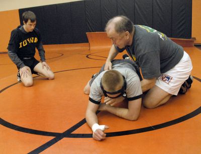 West Valley junior Quinn Gannon watches carefully as wrestling coach John Owen demonstrates a move on Luke Konzal at practice Monday. Gannon finished in first place for the Eagles at 130 pounds at the district tournament last weekend, as first-year coach Owen pushed five wrestlers to the regional tournament. Konzal will wrestle off in the pigtail round to qualify for regionals at 130 pounds. (J. BART RAYNIAK / The Spokesman-Review)