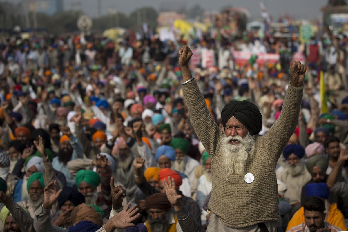 An elderly farmer shouts slogans as others listen to a speaker as they block a major highway during a protest to abolish new farming laws they say will result in exploitation by corporations, eventually rendering them landless, at the Delhi-Haryana state border, India, Tuesday, Dec. 1, 2020. The busy, nonstop, arterial highways that connect most northern Indian towns to this city of 29 million people, now beat to the rhythm of never-heard-before cries of "Inquilab Zindabad" ("Long live the revolution"). Tens and thousands of farmers, with colorful distinctive turbans and long, flowing beards, have descended upon its borders where they commandeer wide swathes of roads.  (Altaf Qadri)