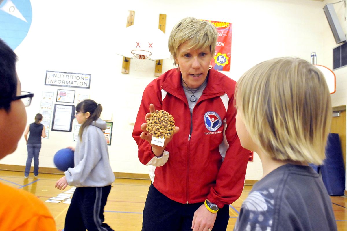 PE teacher PJ Jarvis, center, explains where black-eyed peas fall in the food groups during a nutrition lesson at Opportunity Elementary School. Jarvis was selected as the elementary school teacher of the year by the National Association for Sport and Physical Education. (Jesse Tinsley)