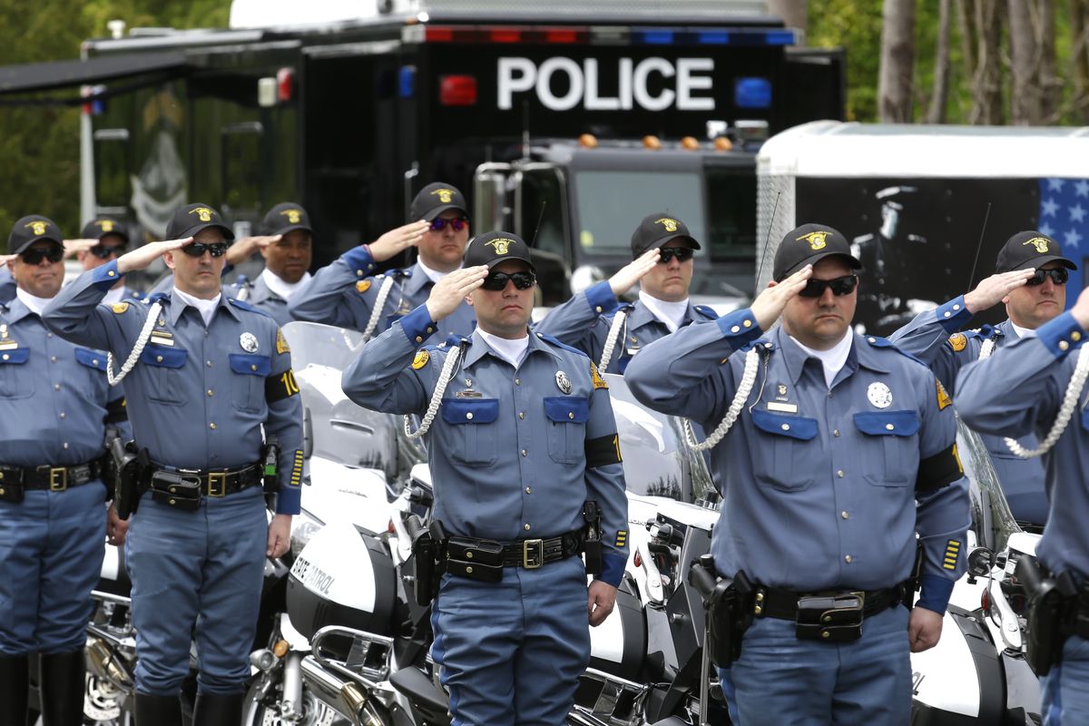 Washington State Patrol troopers salute next to their motorcycles during the annual law enforcement medal of honor ceremony Friday at the Capitol in Olympia. Honorees included Trooper Sean O’Connell Jr., who was killed last May in a motorcycle accident while he was helping with a traffic detour. (Associated Press)