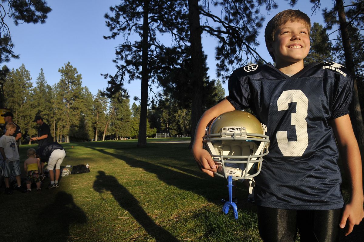 Jacob Keyes, 10, stands in Comstock Park before a football practice last month. Jacob has written a book about the University of Notre Dame and his love of its football program. (Jesse Tinsley)