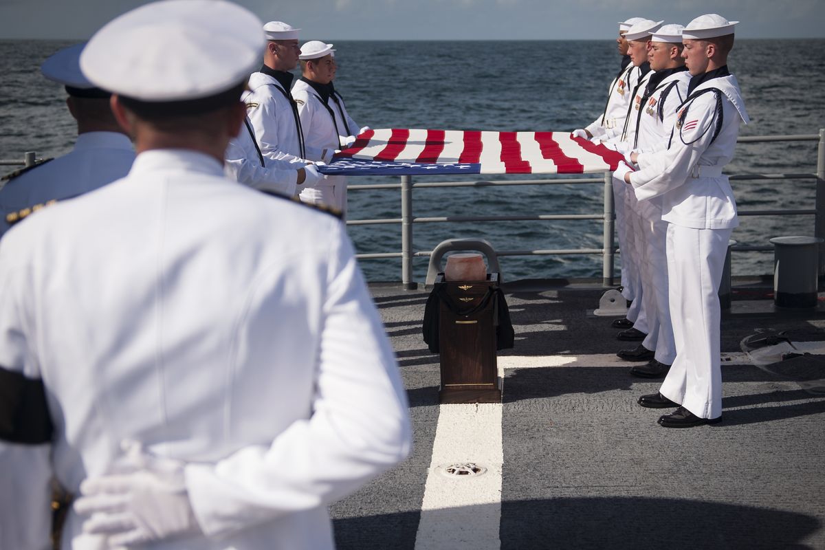Members of the U.S. Navy ceremonial guard hold an American flag over the remains of Apollo 11 astronaut Neil Armstrong during a burial at sea service aboard the USS Philippine Sea (CG 58), Friday, Sept. 14, 2012, in the Atlantic Ocean.  Armstrong, who died last month in Ohio at age 82, walked on the moon in July 1969. (Bill Ingalls / Nasa)